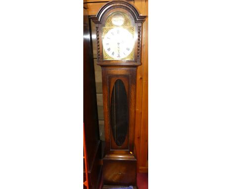 A 1920s oak Tempus Fugit longcase clock, having arched silvered dial with brass spandrels, oval glazed trunk door, having thr
