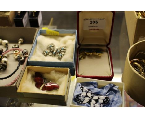 A white metal and enamel decorated butterfly brooch; and three other butterfly brooches 