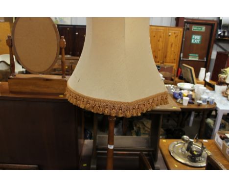 A turned wooden standard lamp and shade
