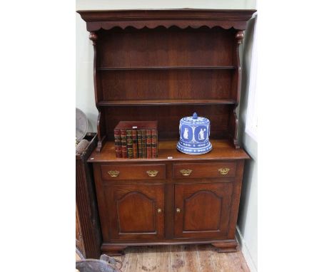 Oak shelf back dresser having two arched fielded panel doors on ogee bracket feet, 116.5cm by 189cm.