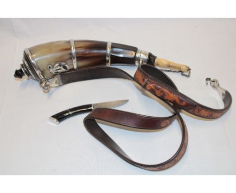 An old cow horn powder flask with silvered mounts and bone stopper, 14" long with attached leather belt mounted with a small 