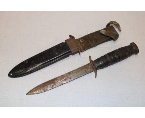 A Second War United States M8 combat knife with single edged blade and leather hilt in composition scabbard