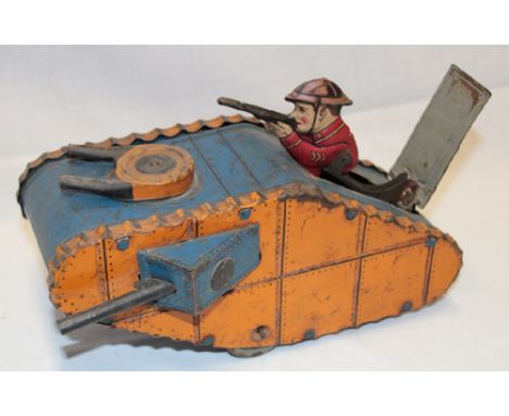 An unusual clockwork tinplate First War tank by Louis Marx & Co New York with rising shooting soldier aperture, 9" long