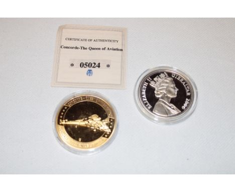 A 2006 silver First Commercial Flight of Concorde commemorative £5 coin and a gilt Concorde crown (2)