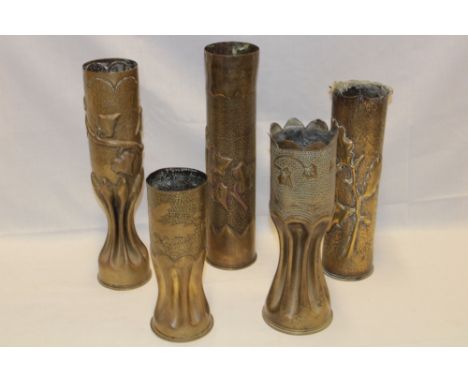 Five various First War trench art shell case vases engraved and decorated in relief with varying designs