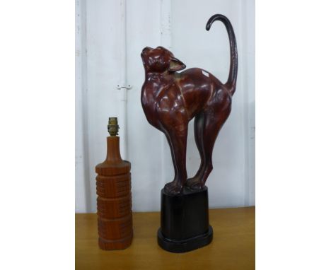 A teak table lamp and a metal figure of a cat 