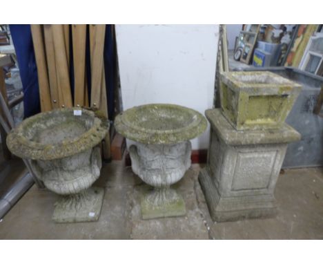 A pair of concrete campana shaped garden urns 