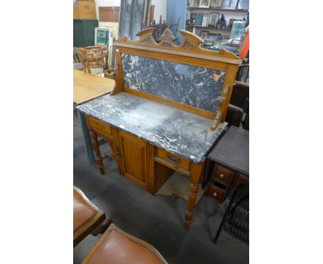 An Edward VII carved walnut and marble top wash stand 