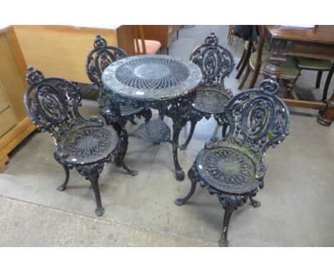 A Victorian painted cast iron garden table and four chairs 