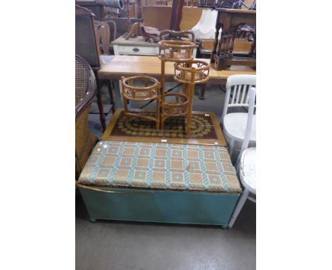 A tiled top teak coffee table, a bamboo plant stand and a wicker ottoman 