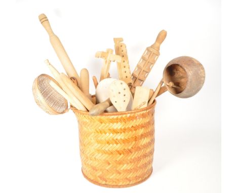 A collection of 20th century kitchenalia hand carved wooden utensils. Including varying form rolling pins, water pot holder, 