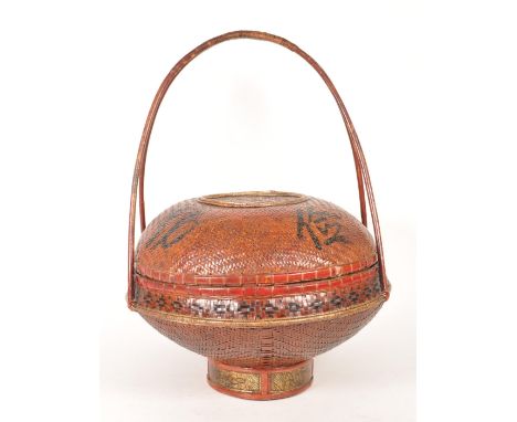 Early 20th century Chinese rattan food hamper. Featuring a red and black colourway with circular lidded form raised on a shor