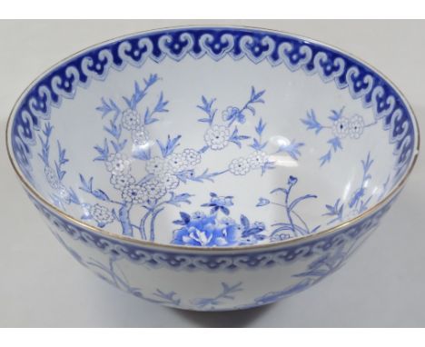 A Kangxi style Chinese bowl, blue and white decorated with flowers and trees, with an upper geometric repeat banding, pseudo 