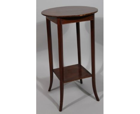 An Edwardian mahogany side table, the circular top with a wide crossbanding raised on sabre supports joined by a shelf beneat