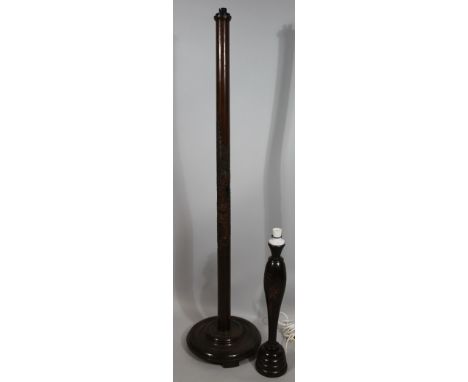 A polished hardwood Eastern style standard lamp, with cylindrical carved stem  on stepped circular foot, 60cm high, and a sim