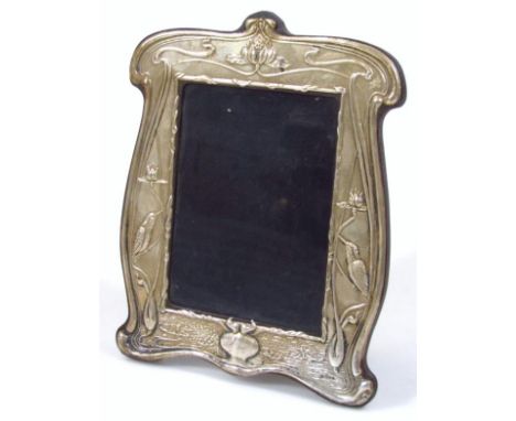 An Art Nouveau silver and oak photograph frame, raised with kingfishers, birds and flowers with easel back and plain glazed f