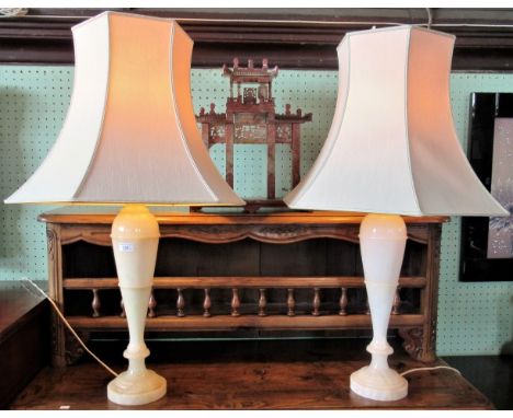 A large pair of alabaster table lamps, complete with cream lamp shades. 