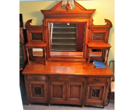 An impressive Edwardian carved oak mirror backed sideboard, with architectural top, central bevelled plate flanked by carved 