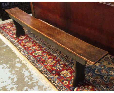 BENCH, 19th century provincial beechwood, stenciled underneath 'Harrods Ltd' 181cm L x 22cm D x 49cm H.