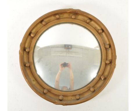 An early 20th century gilt wood and gesso porthole style mirror. The mirror having a rounded frame, surrounding a convex mirr