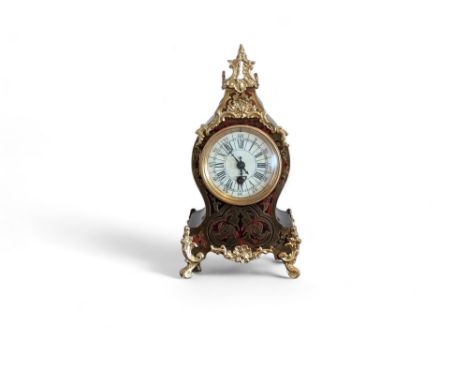 A 19th century Boulle work mantle clock, with atypical pierced brass inlay, the porcelain dial with Roman numerals and Arabic