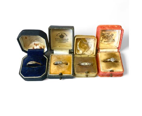 A collection of antique and vintage diamond dress rings, in four vintage cases.  Comprising a diamond daisy ring, stamped "18