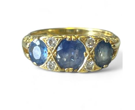 An 18ct yellow gold Sapphire and Diamond ring set with three oral (Ceylon) Sapphires with 2 pair of small diamonds between Sa