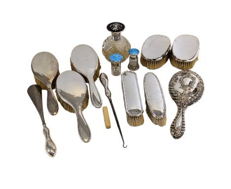 A collection of eight silver back brushes, mirrors, a nail buff, two enamel top bottles and a silver tortoise shell top bottl