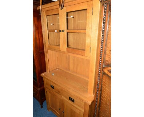 A LIGHT OAK GLAZED TWO DOOR DRESSER with two drawers on cupboard base, approximate width 104cm x depth 40cm x height 197cm