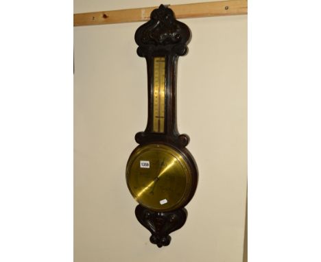 A 20TH CENTURY CARVED OAK ANEROID BAROMETER