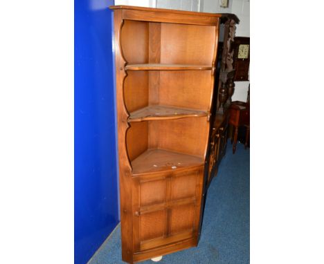 AN ERCOL ASH OPEN CORNER CUPBOARD, with a single cupboard door