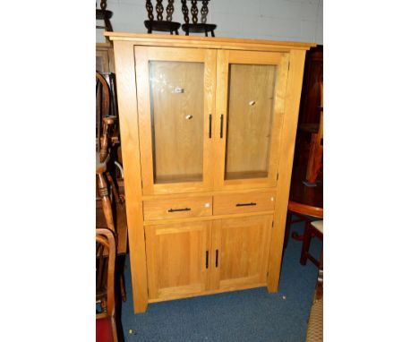 A LIGHT OAK GLAZED TWO DOOR BOOKCASE with two drawers and double cupboard door base, approximate width 118cm x depth 44.5cm x