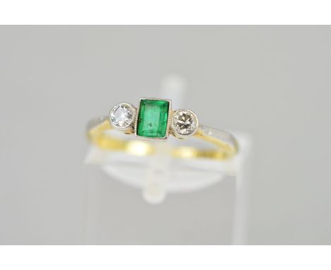 AN EMERALD AND DIAMOND RING, the central rectangular emerald flanked by brilliant cut diamonds, all within millegrain setting