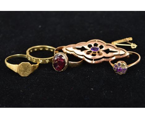 FOUR GOLD RINGS AND A BROOCH to include a late 19th Century oval garnet ring (crack to garnet), ring size N1/2, an early 20th