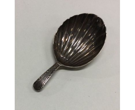 A Georgian silver fluted caddy spoon with bright cut decoration. Approx. 8 grams. Est. £50 - £80.