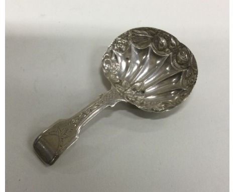 A silver caddy spoon with engraved handle and chased bowl. Birmingham 1827. By Samuel Clark. Approx. 8 grams. Est. £60 - £80.