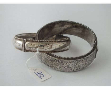 A wide floral engraved silver bangle &amp; one other