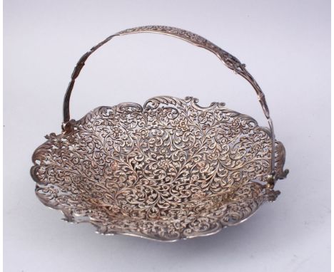 A FINE INDIAN SILVER OPENWORK SWING HANDLED BASKET, of engraved leaf and flower head design, 23cm diameter.
