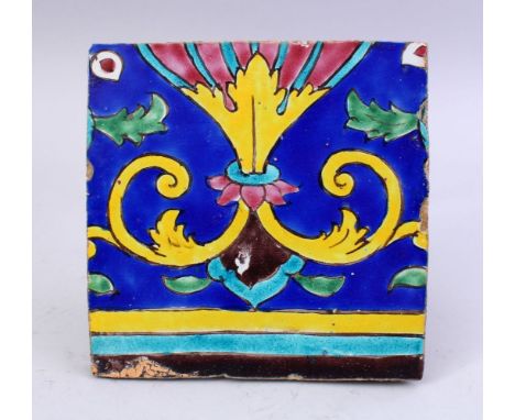 A 19TH CENTURY PERSIAN QAJAR GLAZED POTTERY TILE, with polychromed decoration, 19.5cm wide.