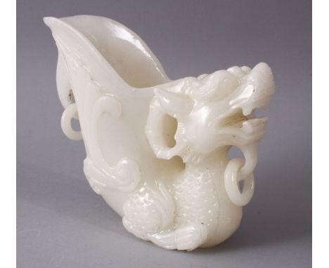 A 29TH CENTURY CHINESE CARVED WHITE JADE LIBATION CUP OF A LION DOG, 14cm high.