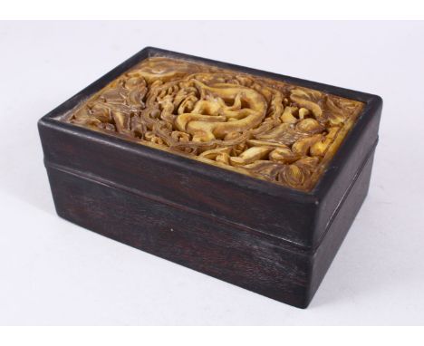 A GOOD CHINESE HARDWOOD &amp; CARVED JADE LIDDED BOX, the jade insert carved with figures and dragons in archaic form, 18cm w