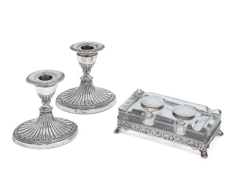 A pair of short Victorian silver candlesticks.Rupert Favell, London, 1885. The knopped stems spreading to fluted oval bases w