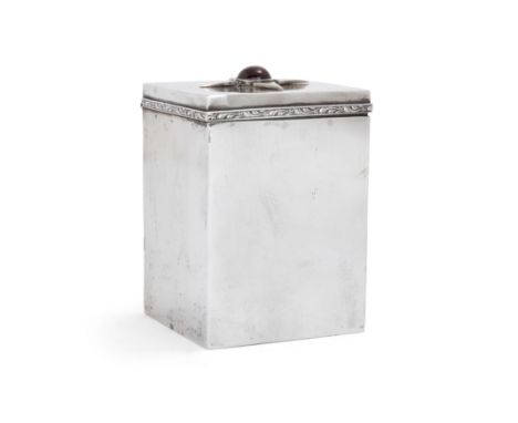 A garnet-set cuboid tea caddy.  Maker's mark FCW. Stamped 'silver'. Of rectangular form, the hinged lid set with a quatrefoil