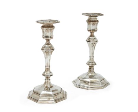 A pair of George V silver candlesticks. Goldsmiths & Silversmiths Co., London, 1912. Raised on octagonal bases, the knopped s