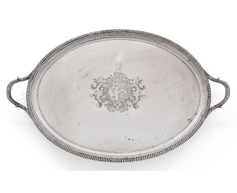 A George III oval silver tea tray. Thomas Hannan and John Crouch. London, 1807. The gadrooned border to twin handles with fol