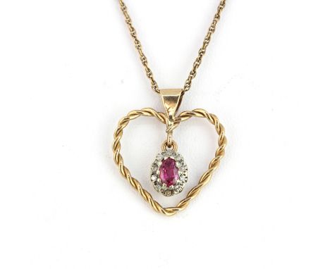 A yellow metal heart shaped pendant set with an oval cut red stone surrounded by diamonds on a 9ct yellow gold chain, L. 44cm