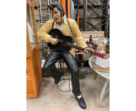A large composition figure of Elvis Presley sitting on a stool, H. 176cm.