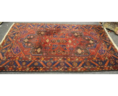 A mid 20th century wool carpet in tones of midnight blue and burnt sienna 144cm x 240cm (approx.)