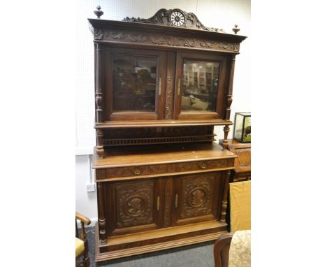 A late 19th Century French Breton buffet side cabinet, in the manner of Henri Deux, surmounted by wheel and acanthus scroll c