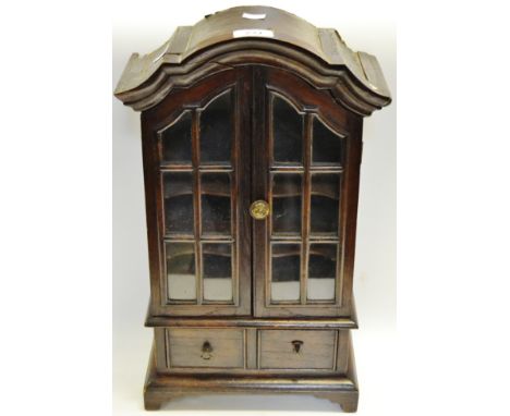 An apprentice made stained mahogany cabinet shaped cornice, adjustable serpentine shelves, two cock beaded drawers, bracket f